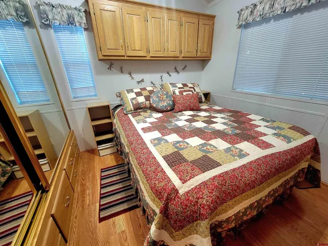 a bedroom with a bed and wooden floor