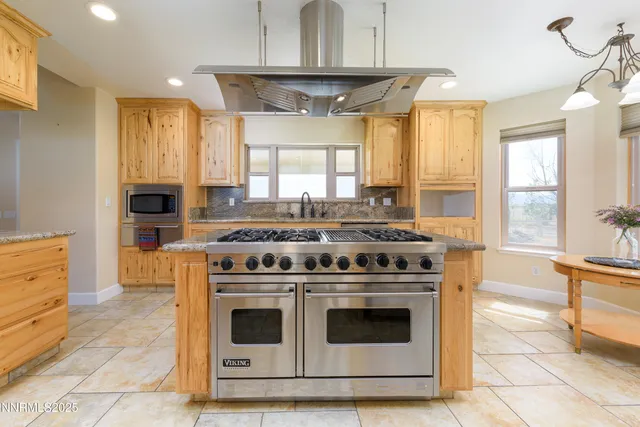a view of a livingroom with wooden floor a ceiling fan and windows