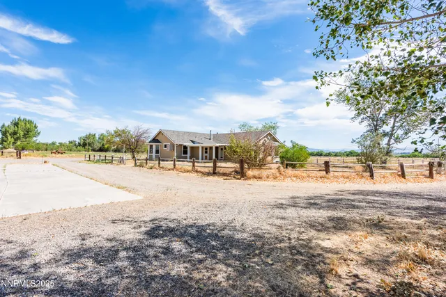 a front view of house with yard and trees in the background