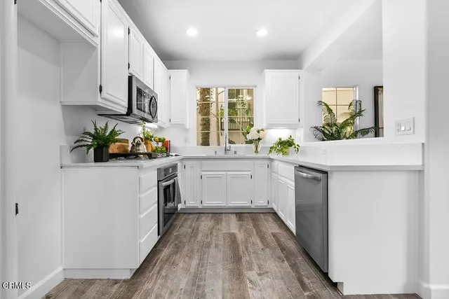 a kitchen with stainless steel appliances white cabinets and a sink