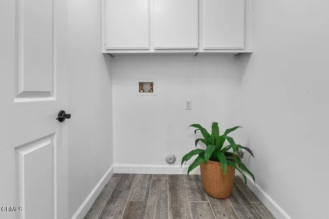 a bedroom with a bed table flowerpot and window