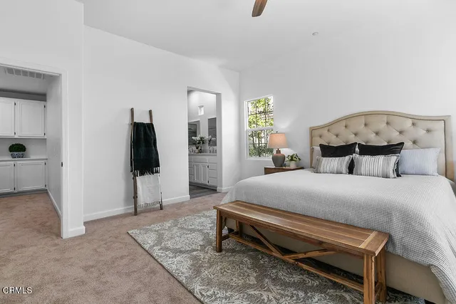 a bed sitting in a bedroom next to a window