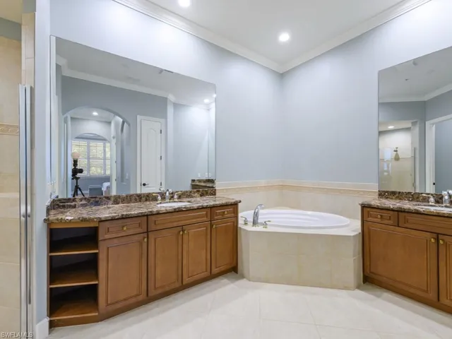a spacious bathroom with a granite countertop sink a toilet a mirror and bathtub