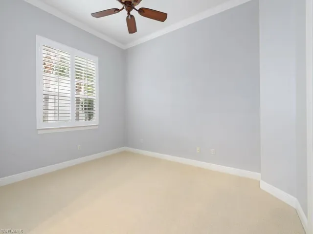 an empty room with a window and a fan