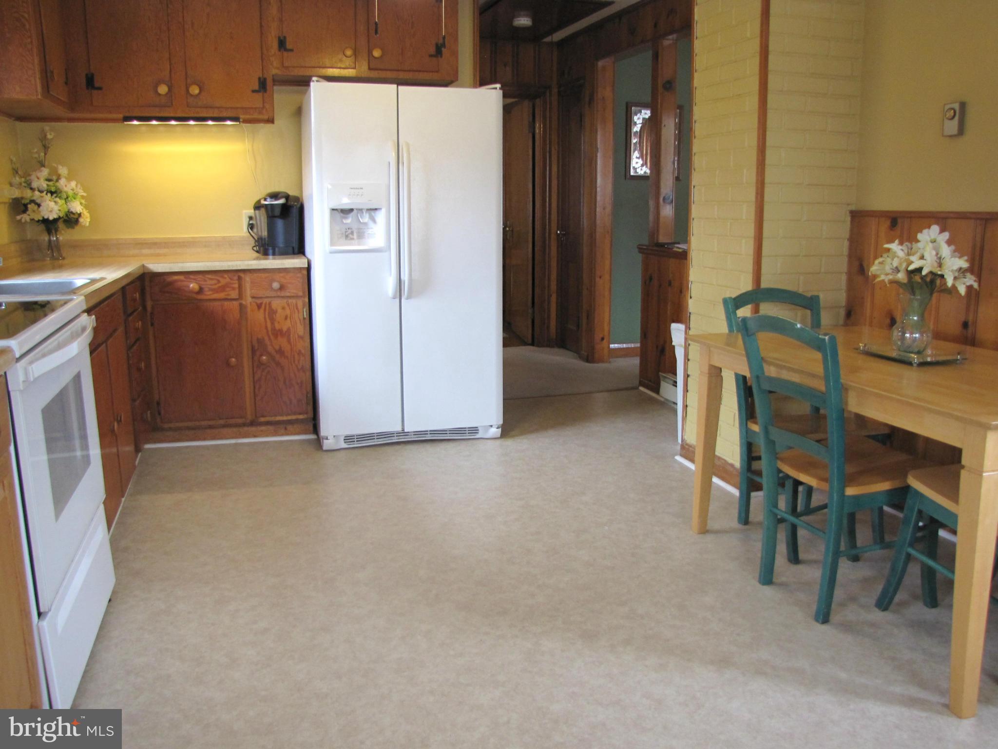 27 Brookfield Road Pasadena, MD 21122 - Photo 7 of 20 a kitchen with refrigerator and table