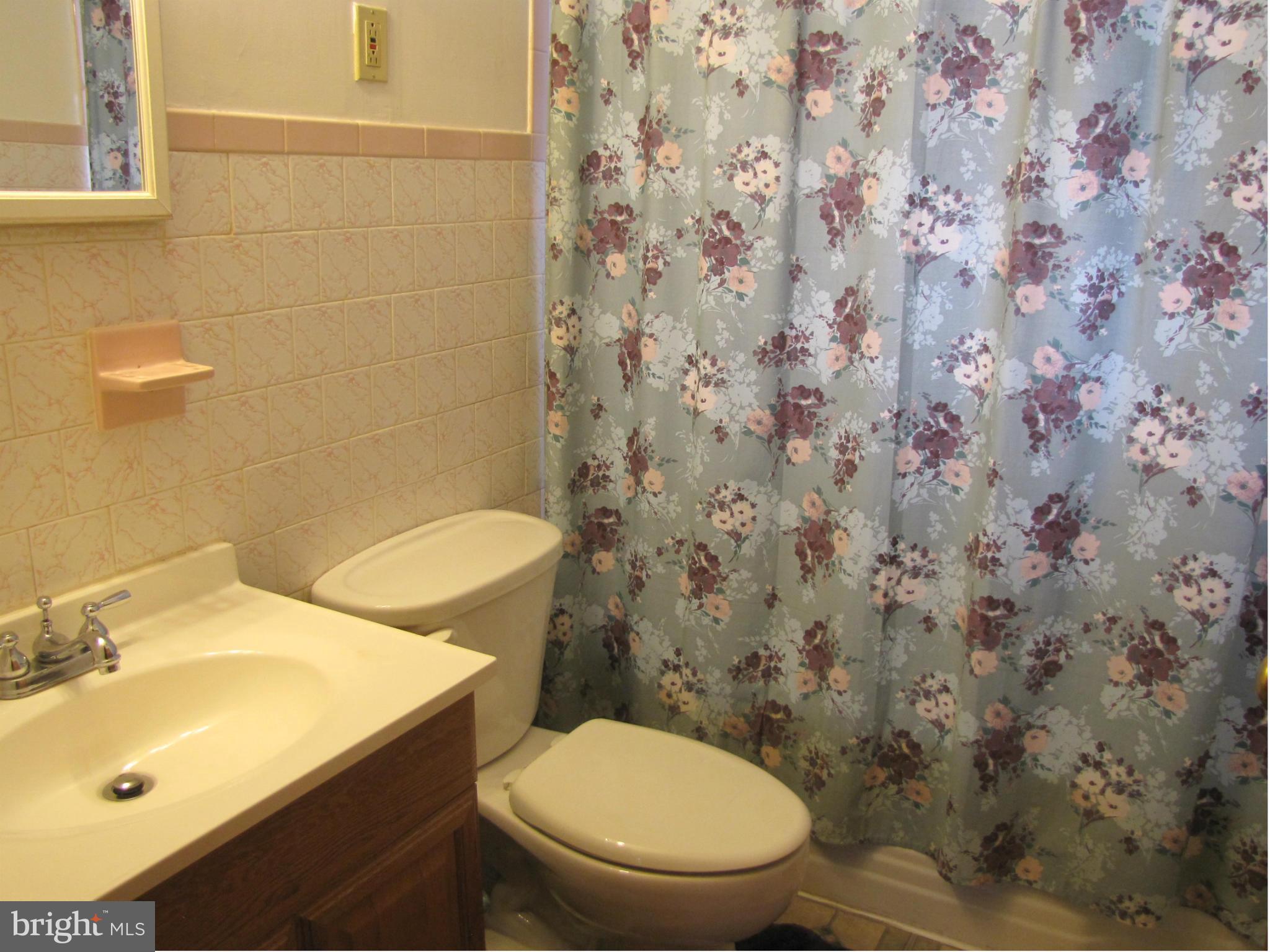 27 Brookfield Road Pasadena, MD 21122 - Photo 8 of 20 a white toilet sitting next to a bathroom sink
