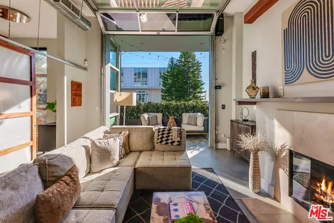 a living room with furniture a fireplace and potted plants