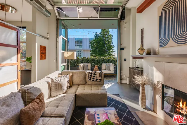 a living room with furniture a fireplace and potted plants