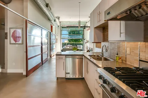 a kitchen with stainless steel appliances a stove a sink and a refrigerator