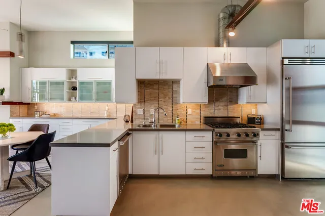 a kitchen with stainless steel appliances a stove a sink and a refrigerator