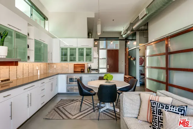 a kitchen with granite countertop a sink and white cabinets