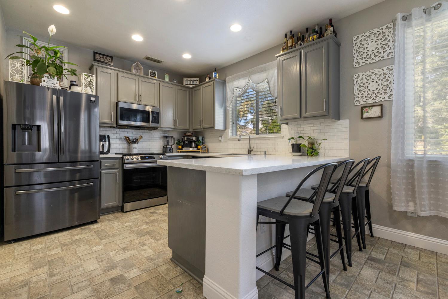 3145 Sweet Pea Avenue Merced, CA 95341 - Photo 11 of 25 a kitchen with stainless steel appliances granite countertop a stove refrigerator sink and cabinets