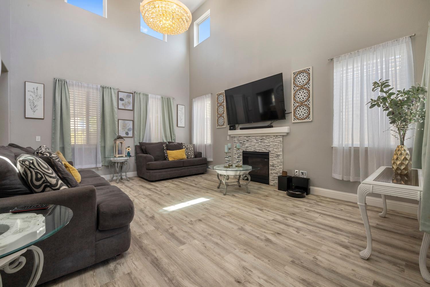 3145 Sweet Pea Avenue Merced, CA 95341 - Photo 5 of 25 a living room with furniture a fireplace a flat screen tv and potted plant