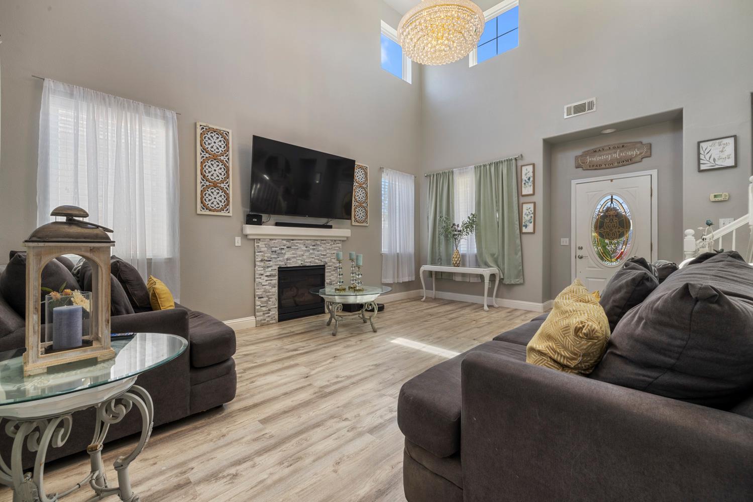 3145 Sweet Pea Avenue Merced, CA 95341 - Photo 6 of 25 a living room with furniture a flat screen tv and a fireplace