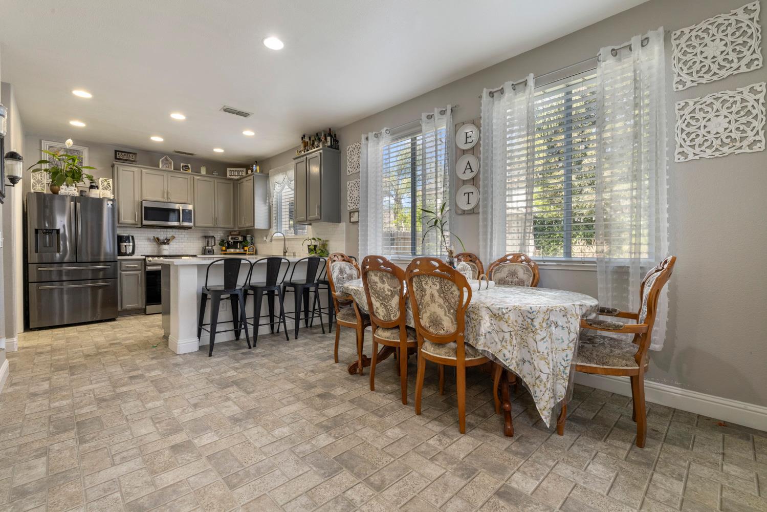3145 Sweet Pea Avenue Merced, CA 95341 - Photo 10 of 25 a dining hall with stainless steel appliances a dining table and chairs