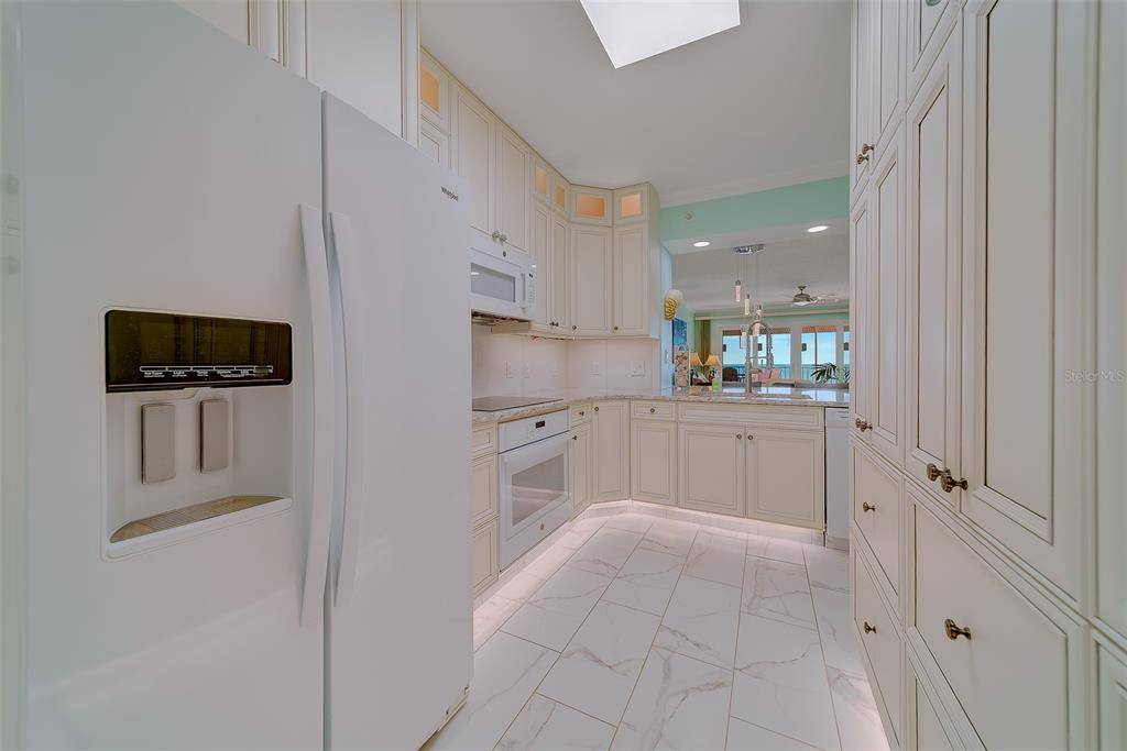 16450 Gulf Boulevard, Unit 565 North Redington Beach, FL 33708 - Photo 13 of 52 a kitchen with white cabinets and white appliances