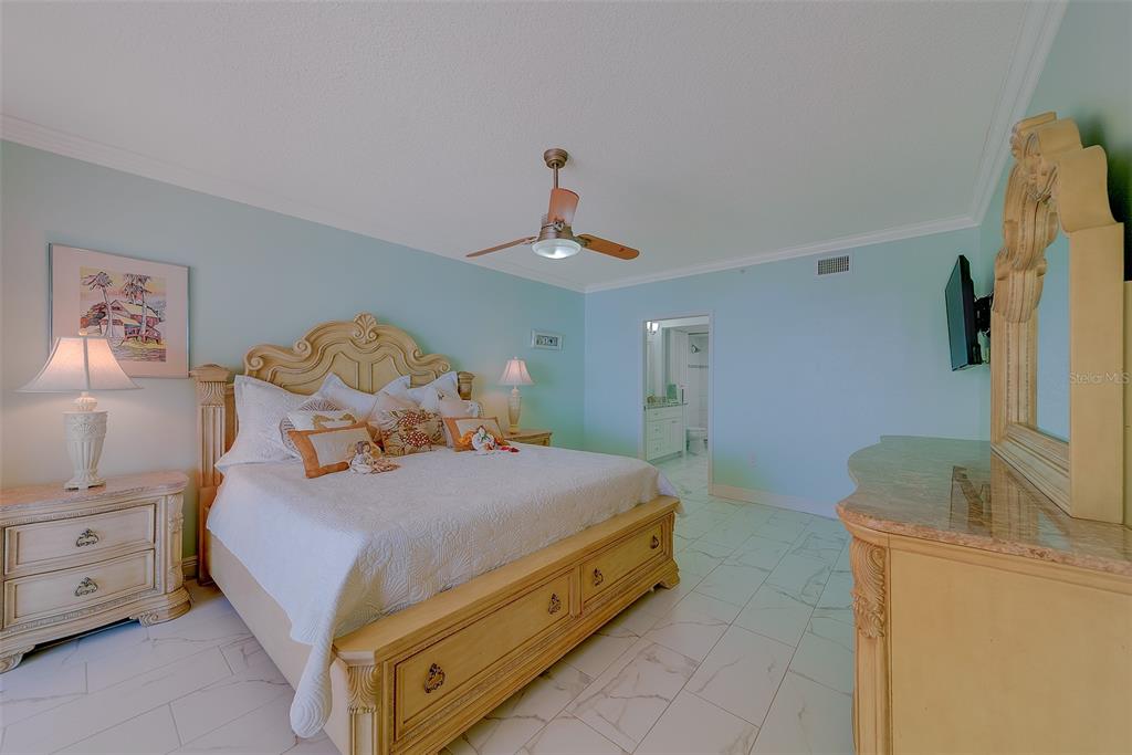 16450 Gulf Boulevard, Unit 565 North Redington Beach, FL 33708 - Photo 21 of 52 a bedroom with a bed and a chandelier