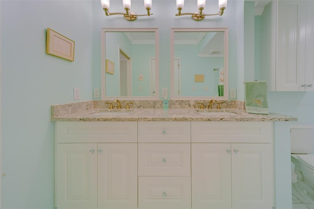 16450 Gulf Boulevard, Unit 565 North Redington Beach, FL 33708 - Photo 23 of 52 a bathroom with a granite countertop sink and a mirror