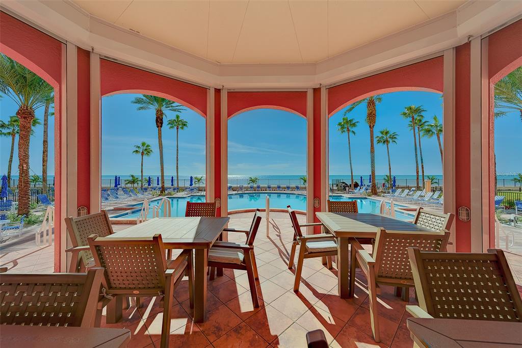 16450 Gulf Boulevard, Unit 565 North Redington Beach, FL 33708 - Photo 38 of 54 a dining room with furniture a rug and a floor to ceiling window