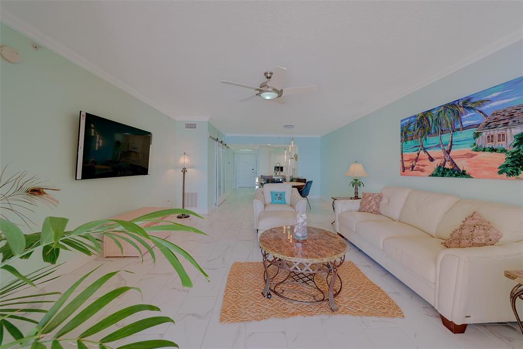 16450 Gulf Boulevard, Unit 565 North Redington Beach, FL 33708 - Photo 7 of 52 a living room with furniture a flat screen tv and paintings on the wall