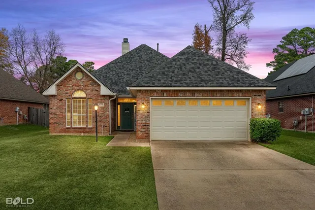 a front view of a house with a garden and yard