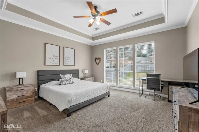 a bedroom with a bed a table and large window