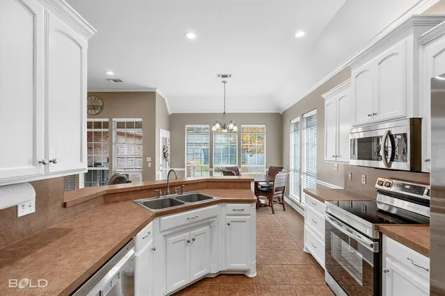 a large kitchen with stainless steel appliances granite countertop a lot of counter space and a sink
