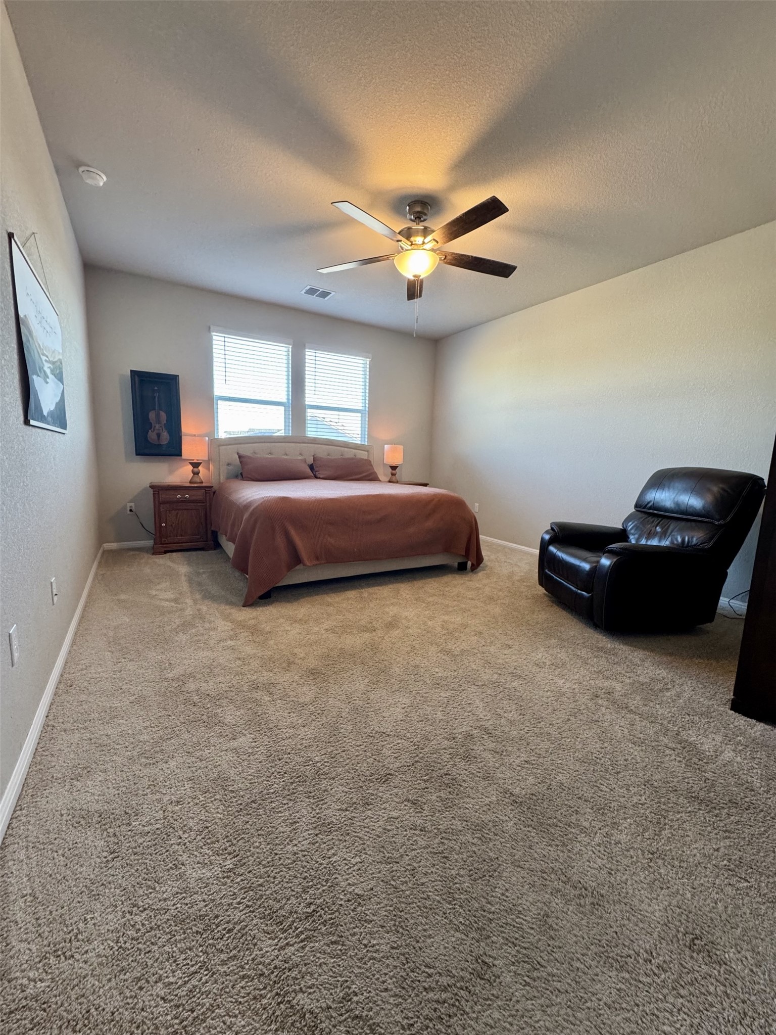 107 Hamilton Pool Lane Bastrop, TX 78602 - Photo 12 of 22 Bedroom with light colored carpet, a ceiling fan.
