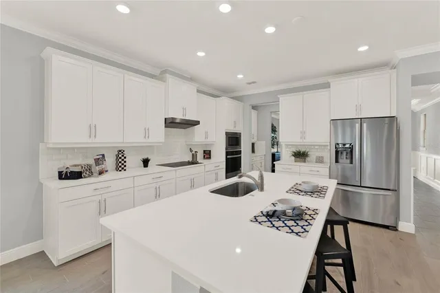 a kitchen with white cabinets and stainless steel appliances