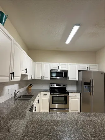 a kitchen with stainless steel appliances granite countertop a stove a sink and a refrigerator