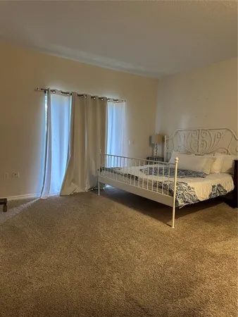 a view of a bedroom with furniture and window