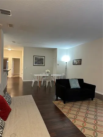 a living room with furniture and wooden floor