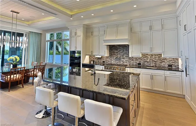 a kitchen with stainless steel appliances granite countertop a stove a sink dishwasher a microwave oven and a dining table with garden view