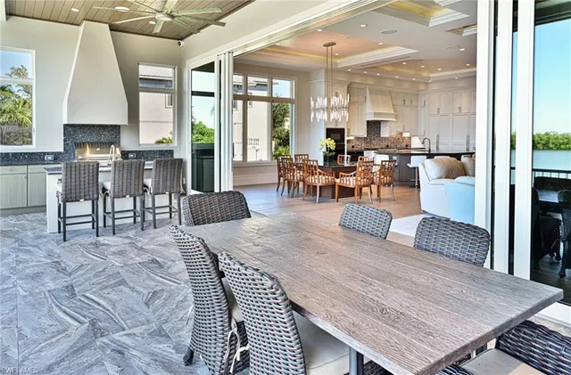 a living room with furniture a large window and wooden floor