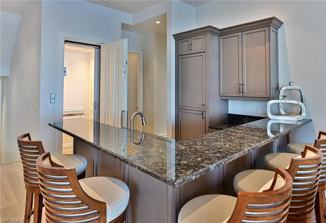 a bathroom with a granite countertop toilet and a sink