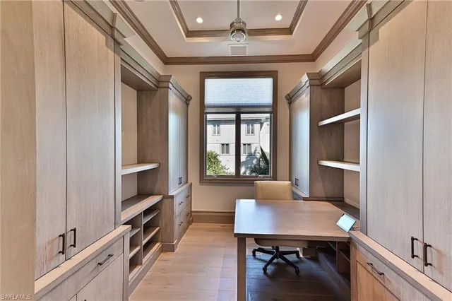 a view of a workspace with furniture and a window