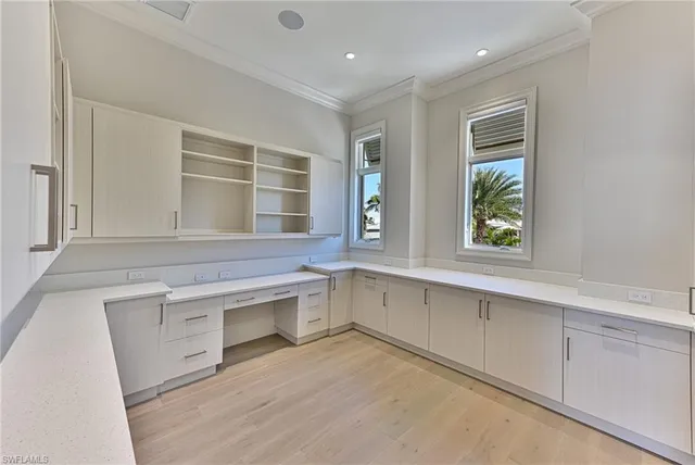 an empty room with windows and cabinet