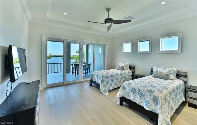 a bedroom with two beds and a flat screen tv