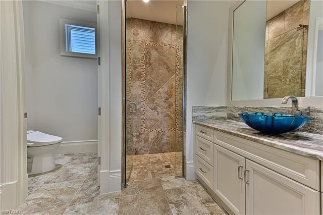 a bathroom with a granite countertop sink a toilet and shower