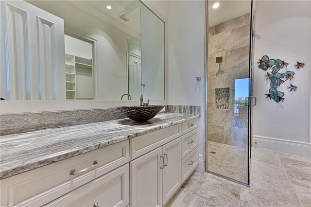 a bathroom with a granite countertop sink a mirror and shower