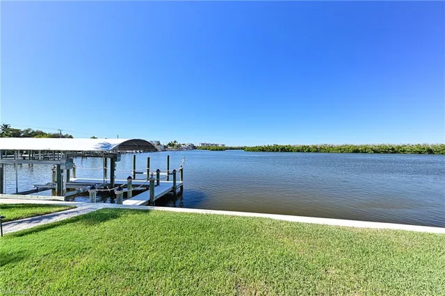 a view of a lake with a house and a big yard