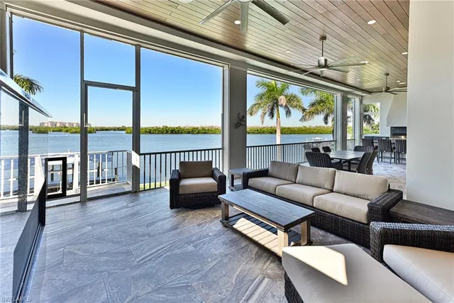 a living room with furniture floor to ceiling window and wooden floor