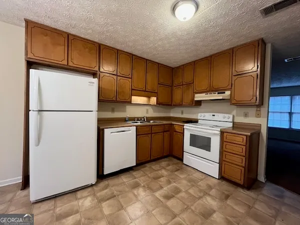 a kitchen with white cabinets and white appliances