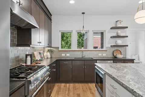 a kitchen with a sink stove top oven and cabinets