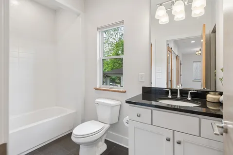 a bathroom with a granite countertop toilet a sink and a bathtub