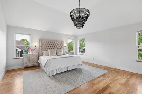 a bed sitting in a spacious bedroom next to a window