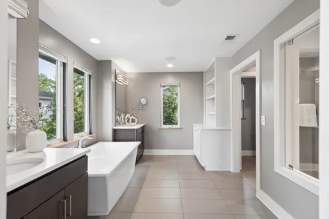 a bathroom with a tub sink and mirror