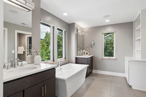 a spacious bathroom with a sink a mirror and a bathtub