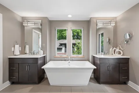 a spacious bathroom with a tub sink and mirror
