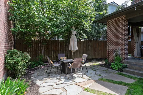 a view of backyard with outdoor seating a patio and plants